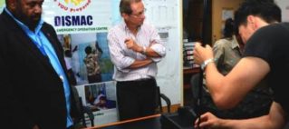 Assistant Minister for National Disaster Management Joeli Cawaki tries out the emergency telecommunications.